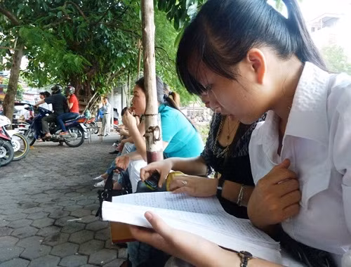 Thí sinh tranh thủ xem lại bài trước giờ vào phòng thi tại HV Ngoại giao (Ảnh Kim Ngân)