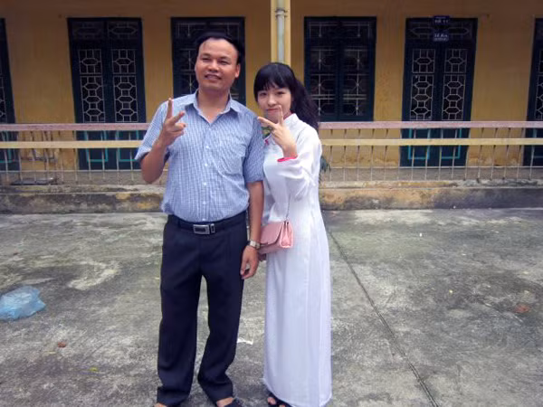 Thủ khoa Đào Thu Hường chụp ảnh chung với người thầy giáo của mình tại trường THPT Cổ Loa.