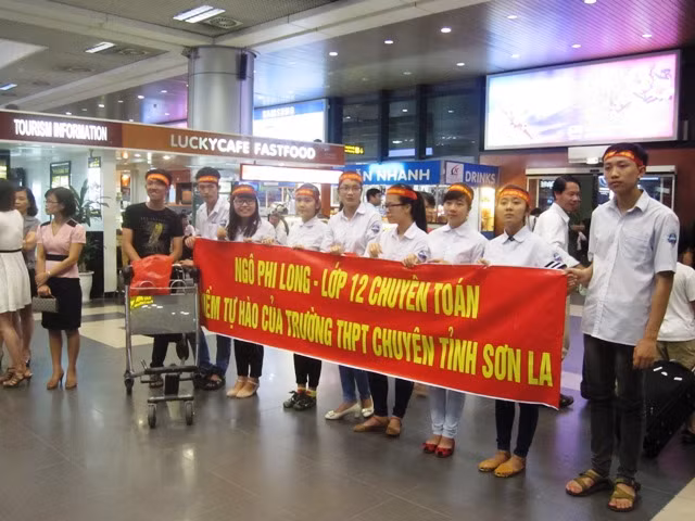 Bạn bè ôm hoa, băng rôn chào đón các thành viên đội tuyển Olympic Vật lí trở về từ Indonesia. Ảnh Xuân Trung Bạn bè ôm hoa, băng rôn chào đón các thành viên đội tuyển Olympic Vật lí trở về từ Indonesia. Ảnh Xuân Trung