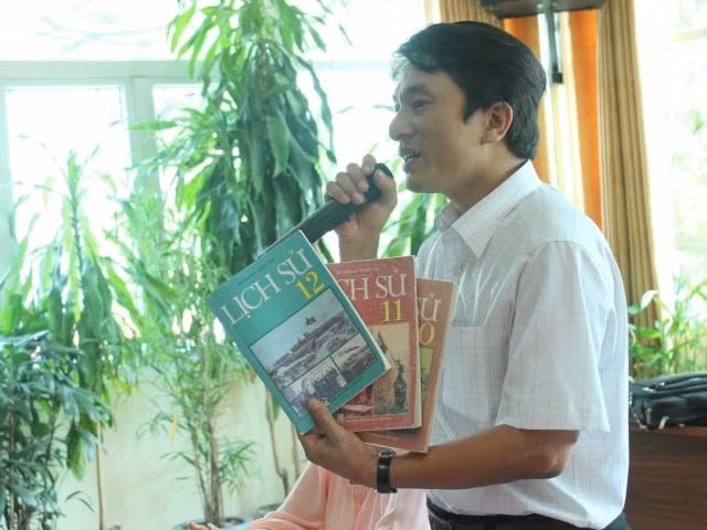 Thầy Trần Trung Hiếu tay cầm quyển SGK Lịch sử phổ thông nói về những bất cập trong nội dung tại Hội thảo về SGK Lịch sử gần đây. Ảnh Xuân Trung