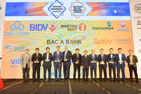 Đại diện Vietcombank, ông Thomas William Tobin – Giám đốc Khối Bán lẻ (thứ 5 từ trái sang) nhận kỷ niệm chương do Ban Tổ chức trao tặng