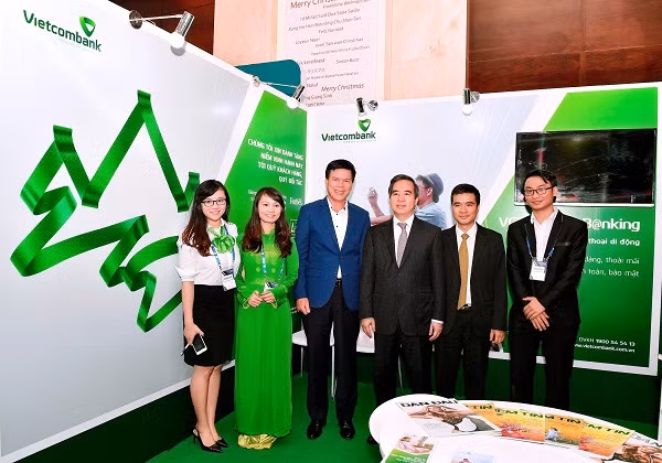 Ông Nguyễn Văn Bình - Ủy viên Bộ Chính trị, Bí thư Trung ương Đảng, Trưởng Ban Kinh tế Trung ương (thứ 3 từ phải sang) thăm và chụp ảnh lưu niệm tại gian hàng trưng bày triển lãm của Vietcombank