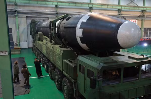 Nhà lãnh đạo Triều Tiên Kim Jong-un thị sát tên lửa Hawsong-15 trước khi di chuyển ra bãi thử (Ảnh: AP)