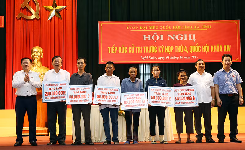 Phó Thủ tướng trao tặng các khoản hỗ trợ cho một số hộ gia đình xây dựng nhà cửa bị hư hỏng do cơn bão số 10. Ảnh: VGP.
