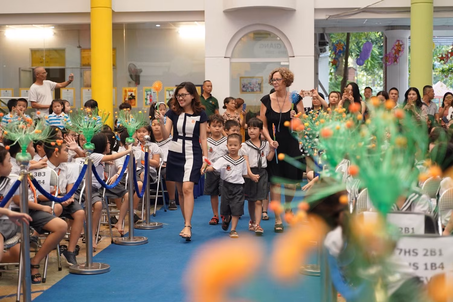 Học sinh lớp 1 được cầm trên tay một bông hoa tái chế từ báo cũ, ống hút, ni lông… Học sinh lớp 1 được cầm trên tay một bông hoa tái chế từ báo cũ, ống hút, ni lông…