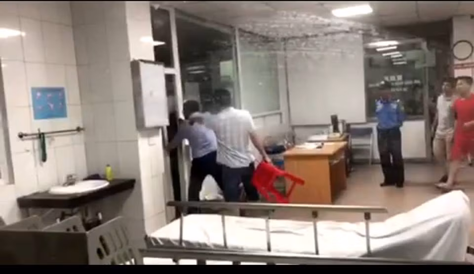 Tại thời điểm xảy ra sự việc có sự xuất hiện của ông Nguyễn Xuân Huân - chủ tịch Ủy ban nhân dân Phường Trung Đô, Thành phố Vinh (người cầm ghế nhựa đỏ). Ảnh cắt từ video.
