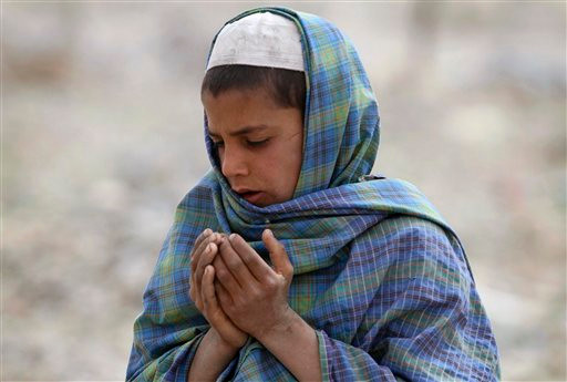 Một cậu bé người Afghanistan đang cầu nguyện bên mộ thân nhân chết trong vụ thảm sát. Ảnh: AP Một cậu bé người Afghanistan đang cầu nguyện bên mộ thân nhân chết trong vụ thảm sát. Ảnh: AP