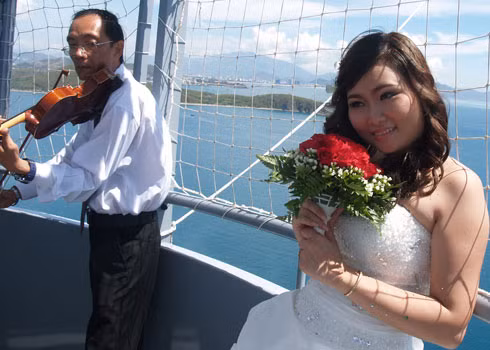 Cô dâu bẽn lẽn khi được người nhạc công chơi bản nhạc chúc mừng. Ảnh: Khuê Việt Trường, VnExpress Cô dâu bẽn lẽn khi được người nhạc công chơi bản nhạc chúc mừng. Ảnh: Khuê Việt Trường, VnExpress