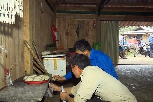 Nghi thức dán giấy lên các công cụ lao động và đồ dùng của người Mông. Ảnh: Hữu Quyết/TTXVN)