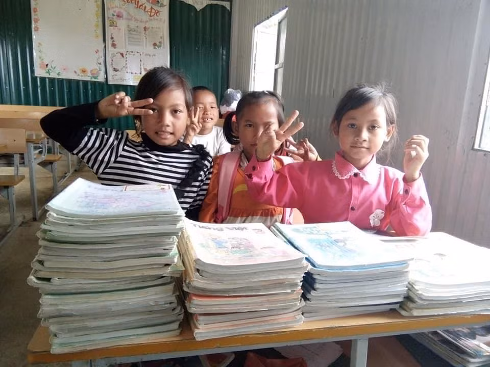Học sinh vùng cao bên cuốn sách cũ có được qua những lần "đi xin" của các thầy cô giáo. (Ảnh: Nhân vật cung cấp)