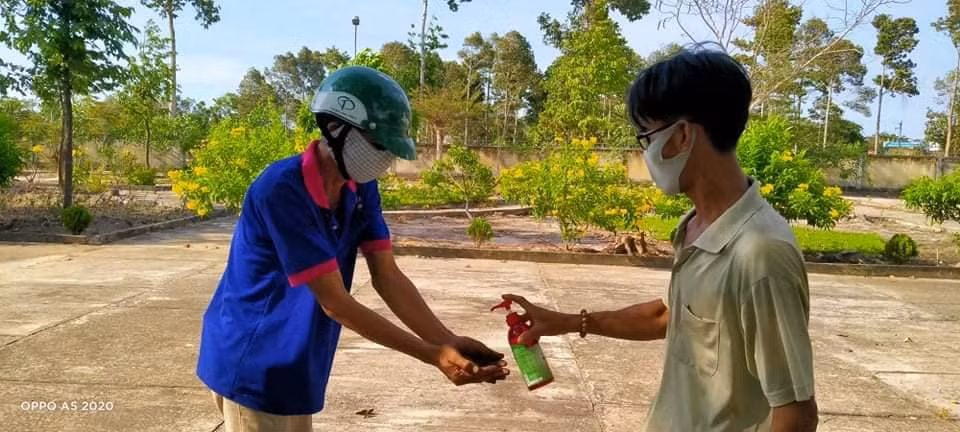 Phụ huynh nhận quà cũng được yêu cầu đeo khẩu trang, rửa tay sát khuẩn trước khi vào trường nhận quà