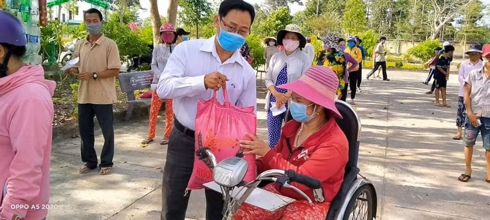 Thầy Lê Văn Chinh, Hiệu trưởng Trường Trung học cơ sở Bưng Riềng phát quà cho người tàn tật tại địa phương