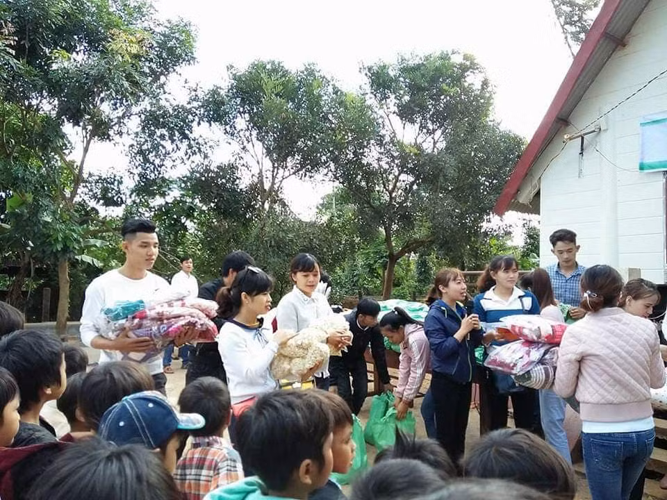 Cô Hà Thị Mai Hương (cầm micro) cùng các giáo viên, tình nguyện viên tặng quà cho học trò nghèo