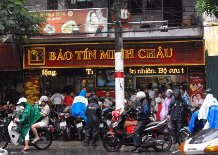 Bất chấp trời mưa rất to nhưng ngay từ sáng sớm ngày 11/8 (giá vàng bất ngờ vọt mốc 46 triệu đồng/lượng), người dân đổ xô lên khu phố Trần Nhân Tông để chờ mua, bán vàng. Ảnh: Cao Nguyên.