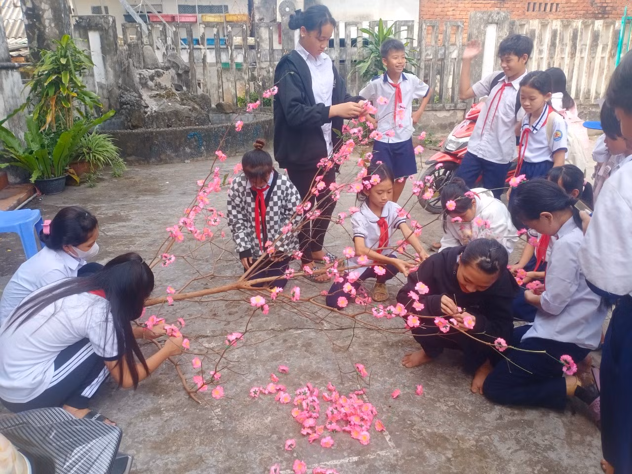 Các bạn học sinh cùng nhau làm cây đào đón tết. (Ảnh: NTCC)
