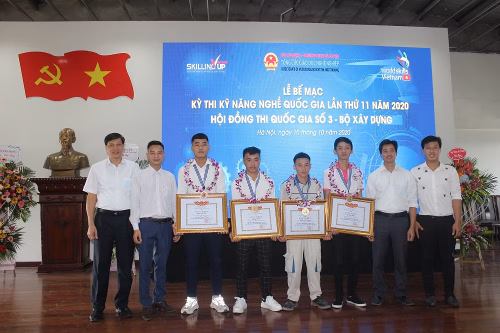 Giàng A Trường (đứng thứ 4 bên phải) và Giàng A Dì (đứng thứ 5 bên phải) nhận bằng khen giải Nhất cuộc thi "Kỹ năng nghề quốc gia năm 2020". (Ảnh: Nhà trường cung cấp)