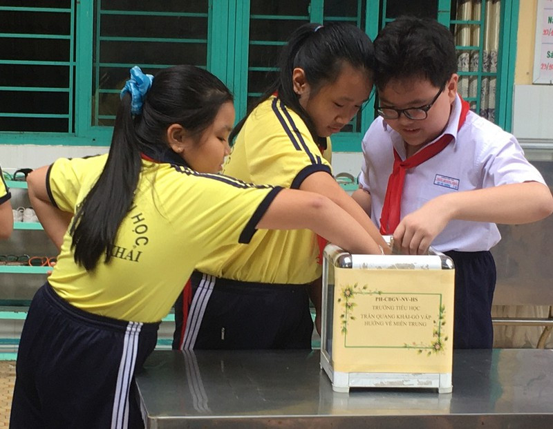 Học sinh trường Tiểu học Trần Quang Khải, quận Gò Vấp, Thành phố Hồ Chí Minh quyên góp tiền hỗ trợ người dân. (Ảnh: Báo Pháp luật Hồ Chí Minh). Học sinh trường Tiểu học Trần Quang Khải, quận Gò Vấp, Thành phố Hồ Chí Minh quyên góp tiền hỗ trợ người dân. (Ảnh: Báo Pháp luật Hồ Chí Minh).