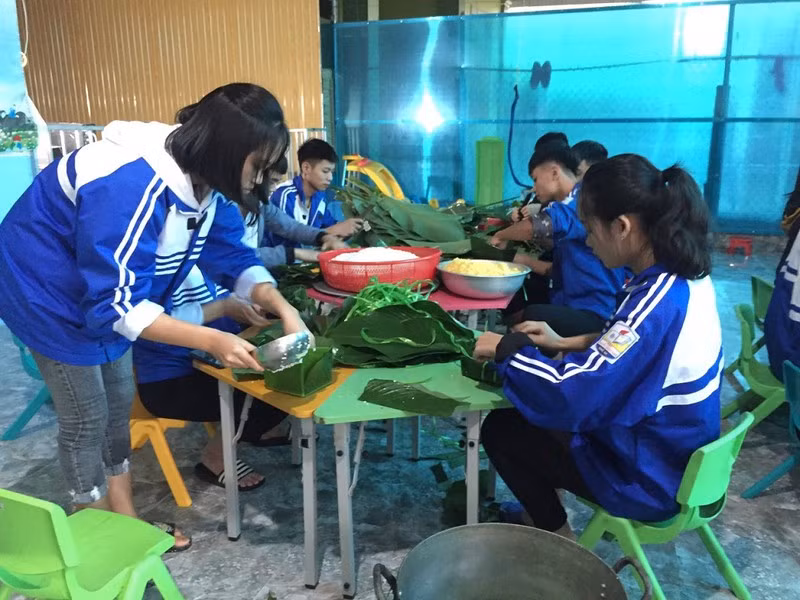 Học sinh Trường Trung học phổ thông Nguyễn Cảnh Chân (Thanh Chương, Nghệ An) gói bánh chưng gửi đến đồng bào miền Trung (Ảnh: Báo Pháp luật Hồ Chí Minh).