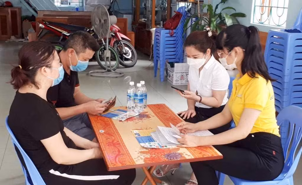 Cán bộ bảo hiểm xã hội hướng dẫn người dân cài đặt VssID trên điện thoại (Ảnh: CTV)