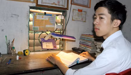Nguyễn Đức Ngà bên góc học tập đơn sơ ở nhà. Ảnh Liêm Thanh Nguyễn Đức Ngà bên góc học tập đơn sơ ở nhà. Ảnh Liêm Thanh