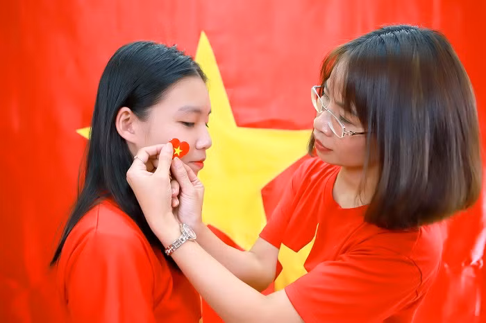 Cô và trò cùng nhau mặc áo cờ đò sao vàng và dán những hình trái tim có ngôi sao vàng năm cánh nổi bật.