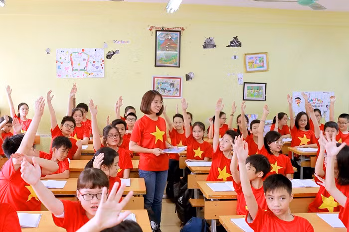 Các em học sinh cùng nhau giơ cao cánh tay, đồng lòng, quyết tâm cổ vũ hết mình cho đội tuyển bóng đá Việt Nam.
