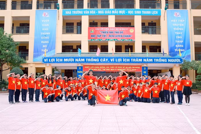 Cả sân trường nhuộm một sắc đỏ rực, các em học sinh cùng nhau căng cờ Tổ quốc thể hiện tinh thần yêu nước.