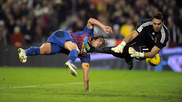 Carles Puyol bay người bắt volley để ghi bàn vào lưới Real Zaragoza.