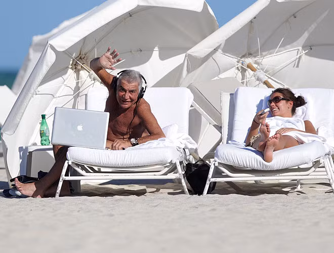 Nhà thiết kế Roberto Cavalli tới đón nắng, gió ở bãi biển Miami cùng bạn gái.