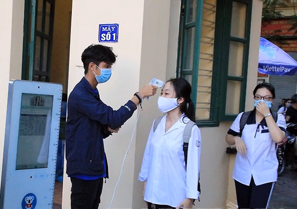 Các thí sinh được đo thân nhiệt ngay từ cổng trường (Ảnh: Lã Tiến)