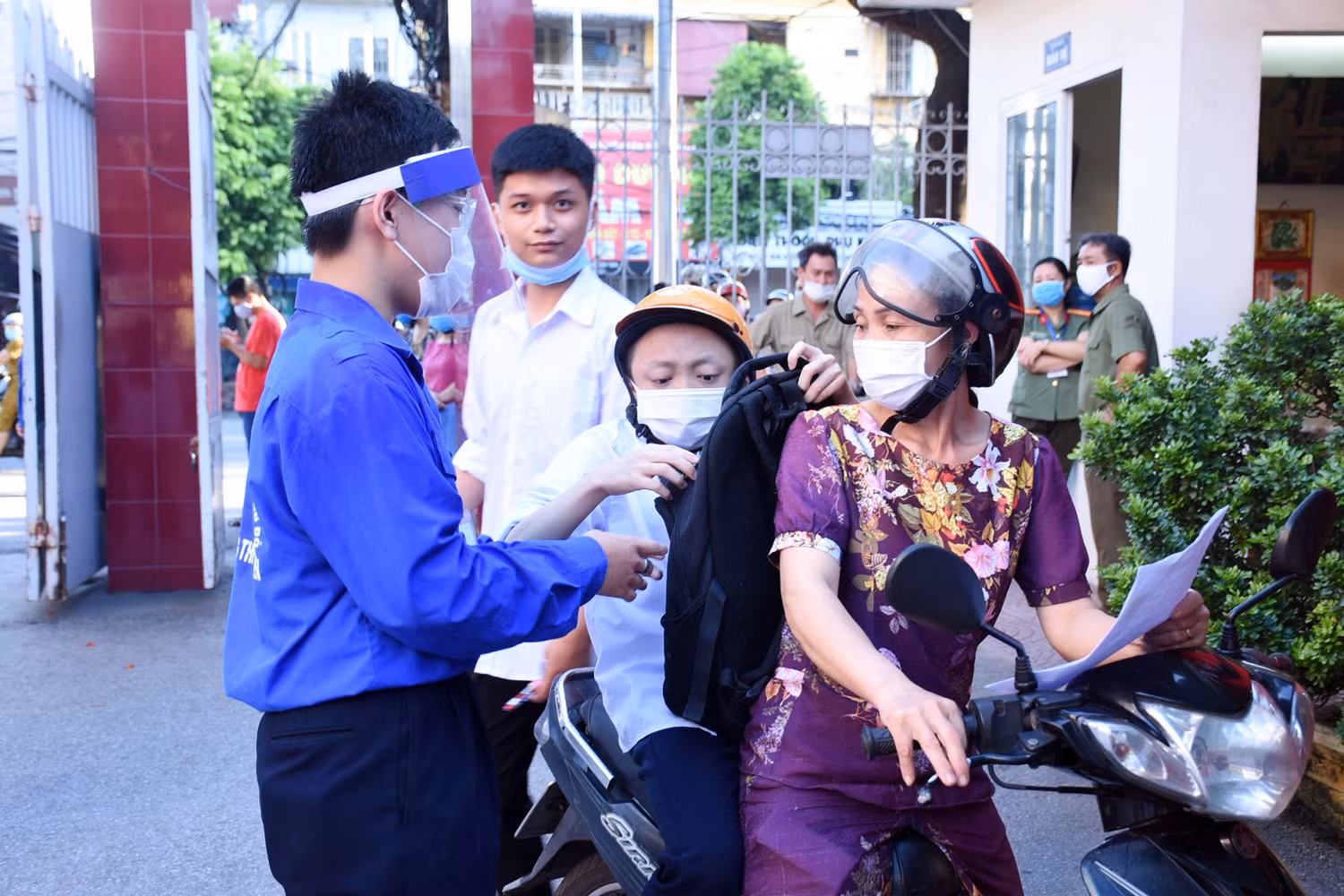 Em Nguyễn Đức Quân, học sinh lớp 12A13, trường Trung học phổ thông Thái Phiên (quận Ngô Quyền, Hải Phòng) bị bệnh "xương thủy tinh" được mẹ chở đến trường dự thi. (Ảnh: Lã Tiến)
