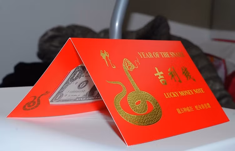 Đồng 1 USD được đặt trong 1 phong bì gấp màu đỏ, có mạ chữ vàng. Theo quan niệm của người phương Đông, màu đỏ và màu vàng tượng trưng cho sự may mắn và tài lộc.