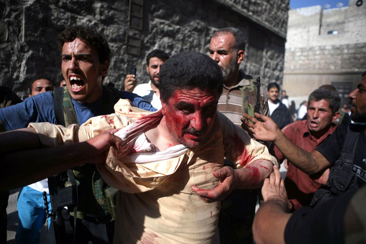 Các tay súng nổi dậy Syria đưa một người đàn ông ủng hộ chính phủ đi hành quyết sau khi chiếm đóng một đồn cảnh sát ở Aleppo.