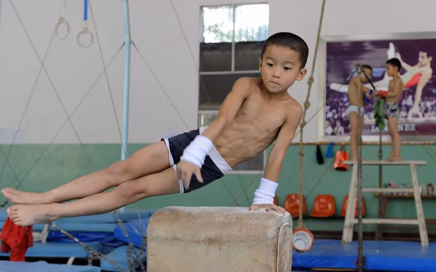 Trẻ em thuộc đội thể dục dụng cụ trong giờ tập luyện tại trung tâm huấn luyện thể thao ở Nam Kinh.