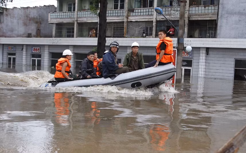 Nhân viên cứu hộ dùng thuyền cao su bơm hơi di chuyển trong thành phố Anju Nhân viên cứu hộ dùng thuyền cao su bơm hơi di chuyển trong thành phố Anju