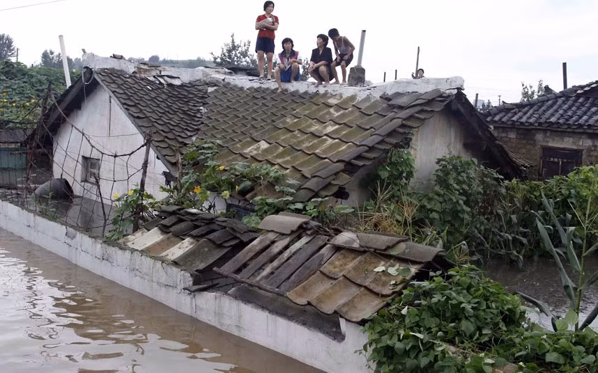 Người dân Triều Tiên tại thành phố Anju, tỉnh Nam Phyongan leo lên mái nhà tránh nước. Người dân Triều Tiên tại thành phố Anju, tỉnh Nam Phyongan leo lên mái nhà tránh nước.