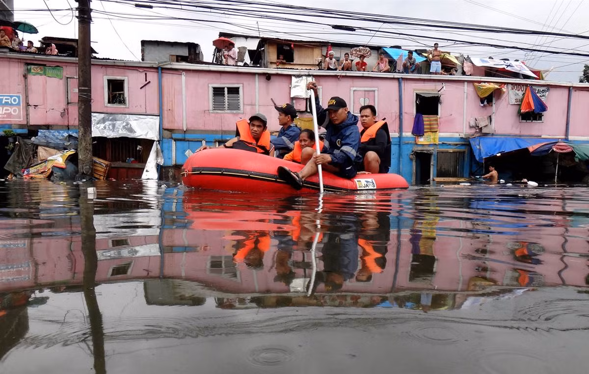 Nhân viên cứu hộ sơ tán một gia đình ra khỏi vùng ngập lụt ở Manila, Philippines ngày 8/8.