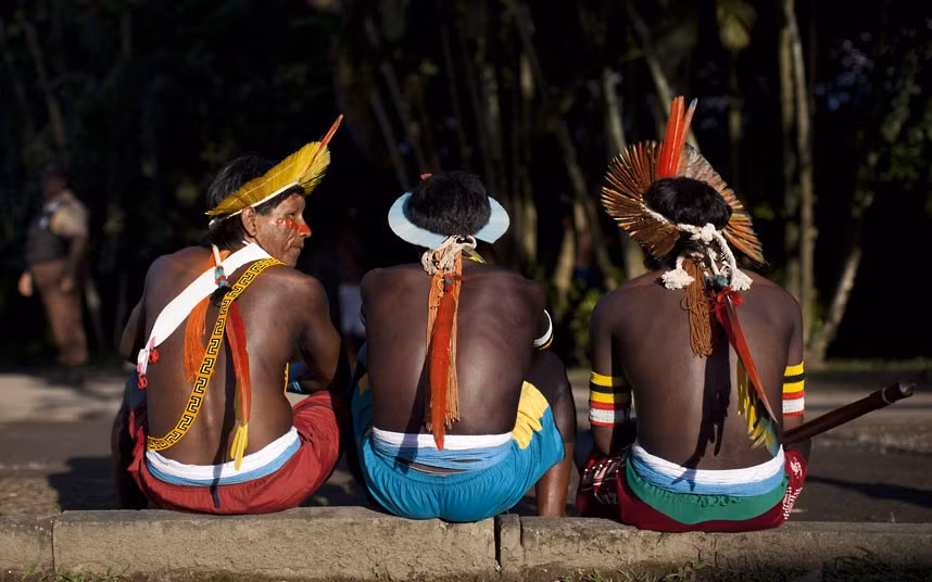 Thành viên bộ lạc Kayapo ngồi trên lề đường ở làng Kari-Oca Thành viên bộ lạc Kayapo ngồi trên lề đường ở làng Kari-Oca