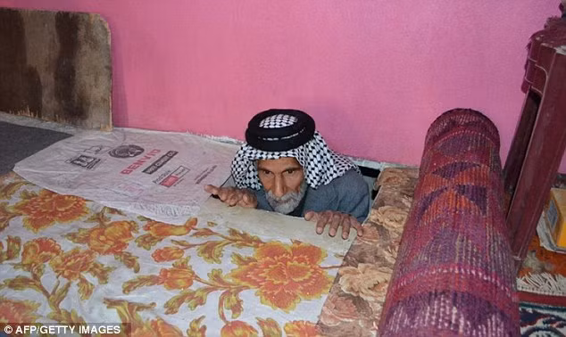 Ông Jawad al-Shammari ở lối vào căn hầm đã che giấu ông suốt 22 năm. Ông Jawad al-Shammari ở lối vào căn hầm đã che giấu ông suốt 22 năm.