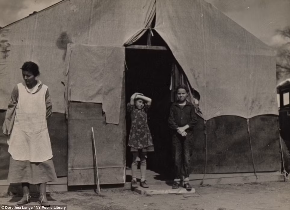Một gia đình di cư đứng trước căn lều của họ ở quận Kern, California, vào năm 1936. Một gia đình di cư đứng trước căn lều của họ ở quận Kern, California, vào năm 1936.