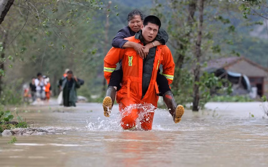 Một nhân viên cứu hộ đưa một người dân lớn tuổi tới khu vực an toàn ở Đài Châu, Chiết Giang. Một nhân viên cứu hộ đưa một người dân lớn tuổi tới khu vực an toàn ở Đài Châu, Chiết Giang.
