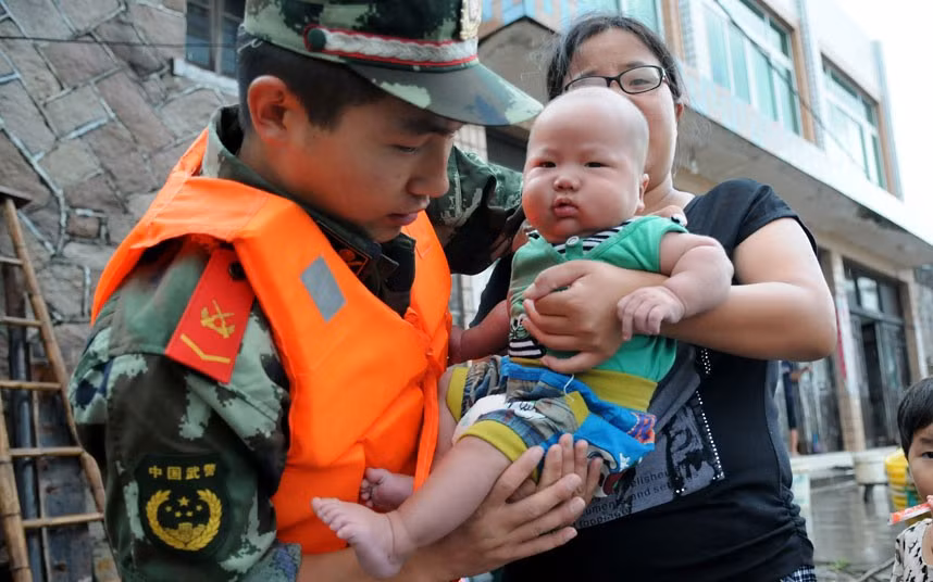 Một quân nhân giúp người dân di tản ở thành phố Ôn Châu. Một quân nhân giúp người dân di tản ở thành phố Ôn Châu.