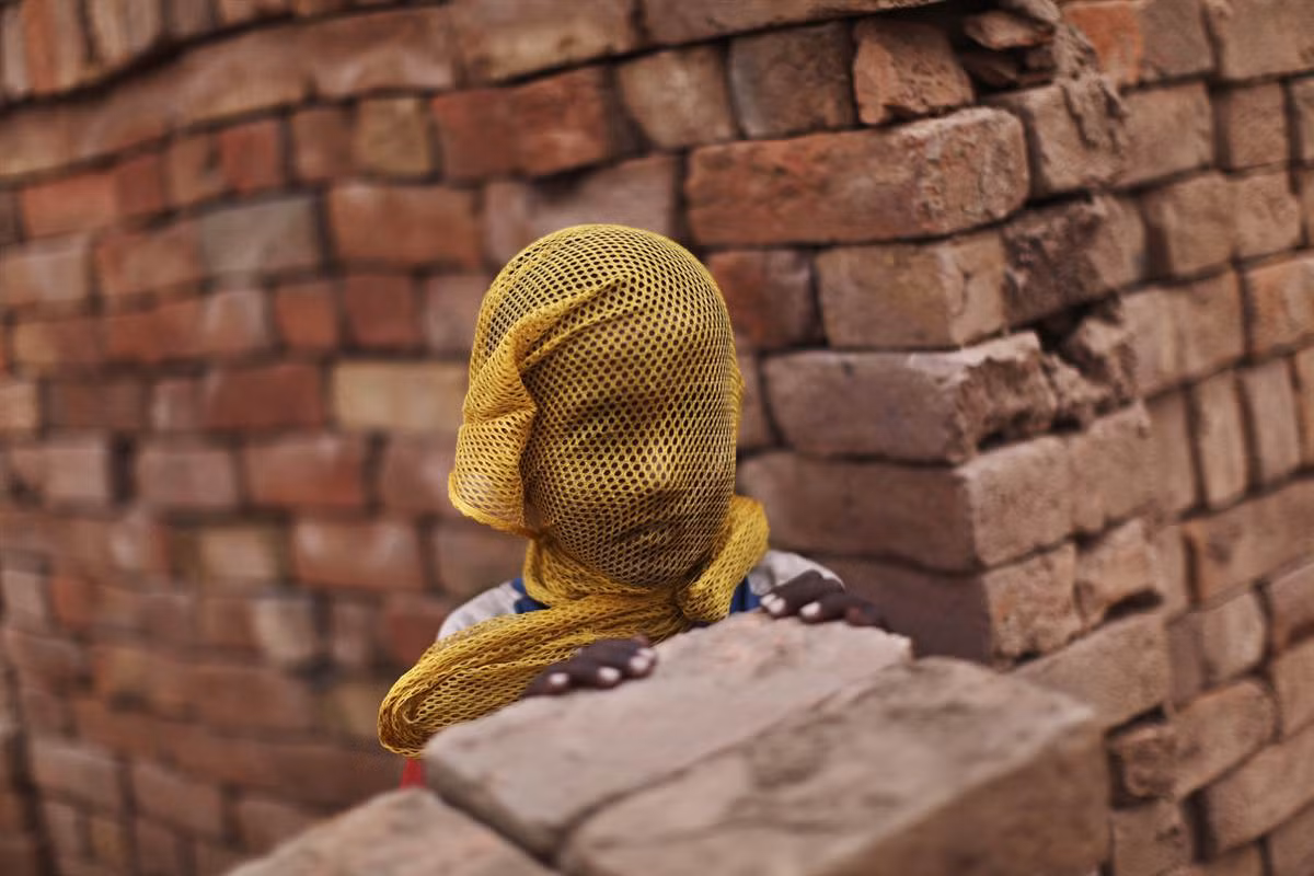 Một cậu bé Pakistan sống gần một nhà máy gạch tại Islamabad, Pakistan dùng khăn bịt mặt để tránh bão cát ngày 6/6.