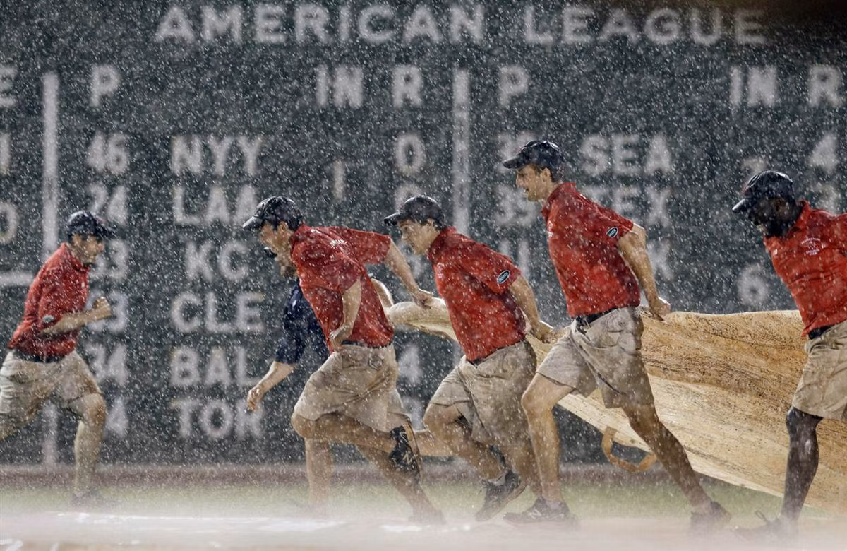 Các nhân viên mang tấm phủ lên sân bóng chày trong hiệp 8 của trận đấu giữa đội Boston Red Sox và Detroit Tigers tại sân Fenway Park ở Boston, Massachussett, Mỹ ngày 29/5.