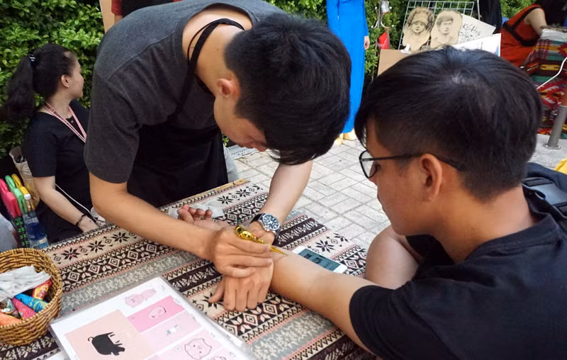 Thanh niên vẽ hình xâm trên tay để chơi Tết. Thanh niên vẽ hình xâm trên tay để chơi Tết.