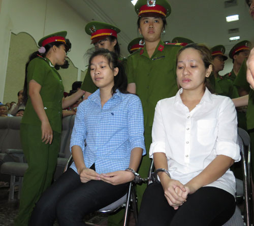Công an đưa bảo mẫu vào bên trong hội trường trước giờ xét xử
