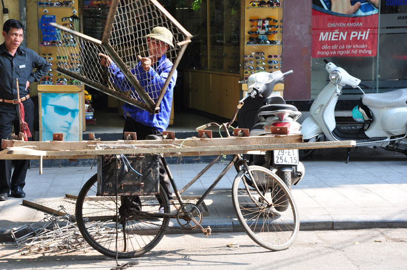 Nét mặt mệt mỏi của người đàn ông thu mua sắt vụn.