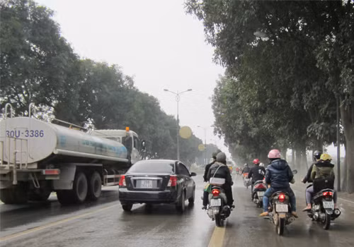 "Xe rửa đường làm sạch người đi đường". Chiếc xe rửa đường chạy trên đường Phạm Văn Đồng ngày 19/3/2012 lúc 10h sáng. Người dân đi xe máy cảm thấy khủng khiếp như thế nào khi dám vượt khỏi dòng nước phun ra cực mạnh từ chiếc xe vệ sinh rửa đường không đúng lúc! Thực tế có nhiều vụ tai nạn nguy hiểm xảy ra khi tránh xe rửa đường. Ảnh: Trần Hải Nam.
