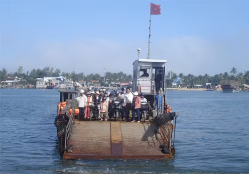 Bàn Than nổi tiếng bởi những khối đá đen xếp chồng lên nhau như tranh vẽ. Để đến được Bàn Than từ Đà Nẵng bạn thẳng tiến quốc lộ 1A đến huyện Núi Thành, Quảng Nam, tại cột mốc cây số 1020 bạn rẽ về phía biển chừng 10 km, một bến phà với cảnh đẹp hiếm có sẽ đưa bạn sang xã đảo Tam Hải. Ảnh: Người dân đi phà qua xã đảo Tam Hải - nơi có ghềnh đá Bàn Than.