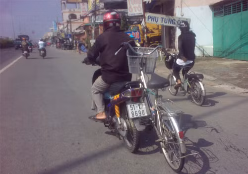Chạy xe máy kéo theo xe đạp. Ảnh: Hà Ngọc Sang